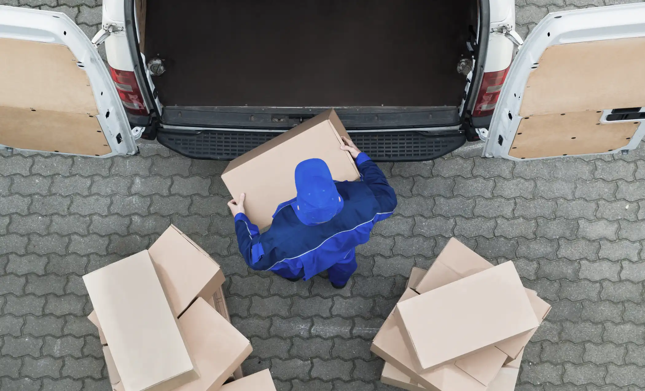 delivery-man-unloading-cardboard-boxes-from-van-on-street